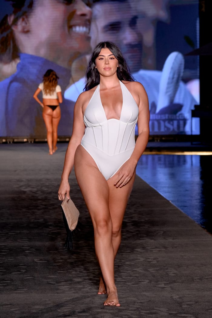 Lauren Chan walks the 2023 Miami Swim Week runway in a white plunging one-piece.
